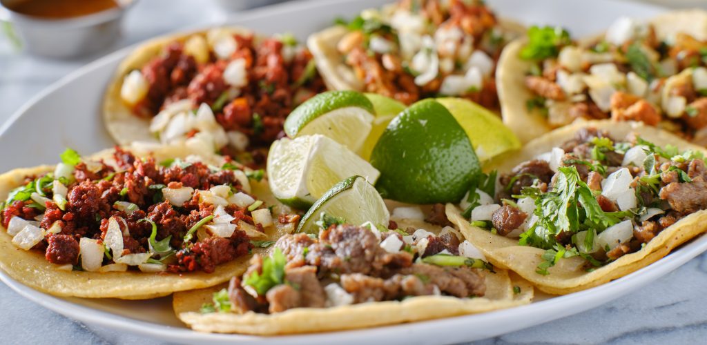 Photo of plate with tacos illustrates blog "Why is Carne al Pastor Called Like That?"