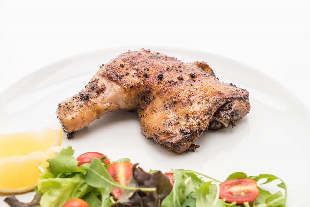 Photo of cooked chicken thigh on plate illustrates blog: "How To Tell If a Chicken Thigh Is Cooked?"